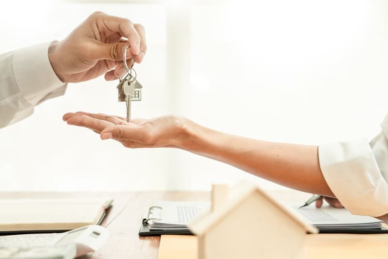 agente de real estate dandole las llaves y el contrato de su nueva casa