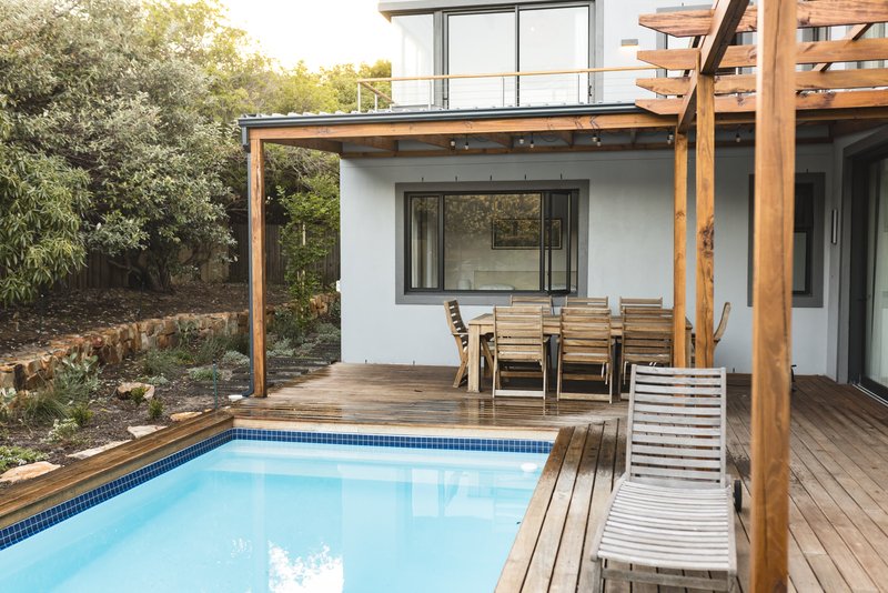Casa con alberca en el patio, con camastros y sillas